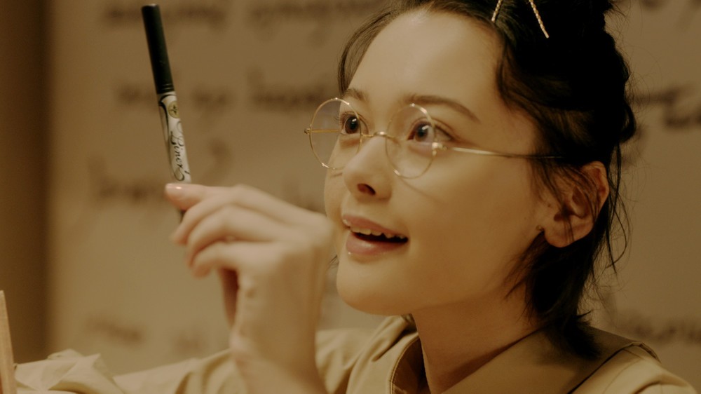 リキッドアイライナーを手に取った少女が喜ぶシーン