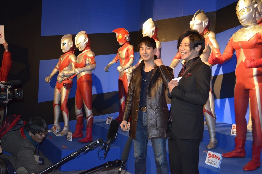 歴代ウルトラヒーローの立像の前でインタビューに応じる、ゲストの2人