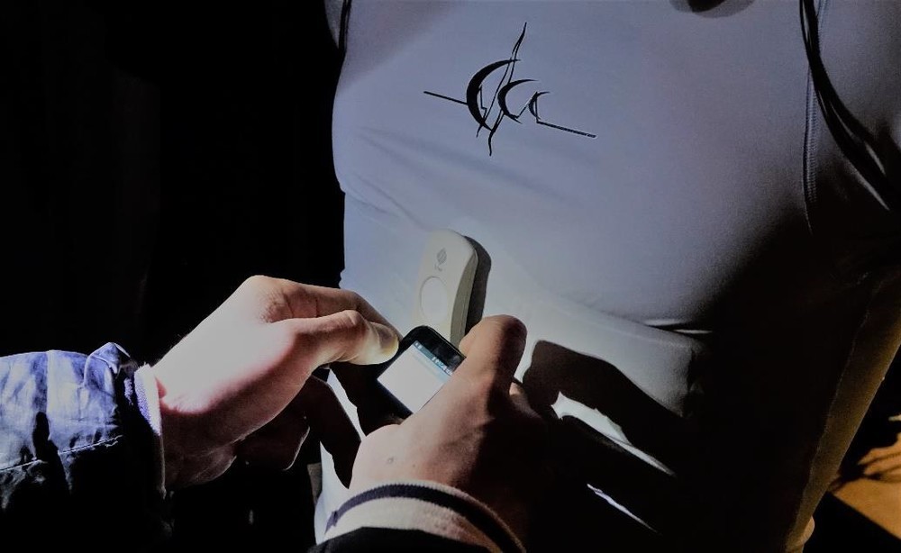 みぞおち部分にあるデバイスが「hitoeトランスミッター01」