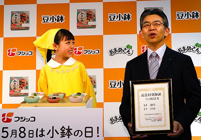 囲み取材で北島取締役の話を笑顔で見守る2代目ふじっ子ちゃん