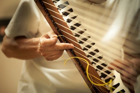 箜篌の復元制作の最終仕上げは、絹糸のチューニングだ。そもそも轉軫箜篌の「轉軫」（てんじん）とは糸巻のこと。器用に絹糸を張って調弦していく。