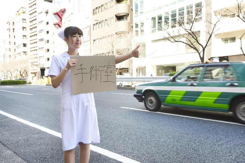 「ヒッチハイクする看護師」