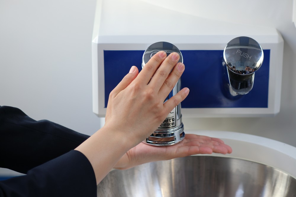 手を添えてボタンを押す