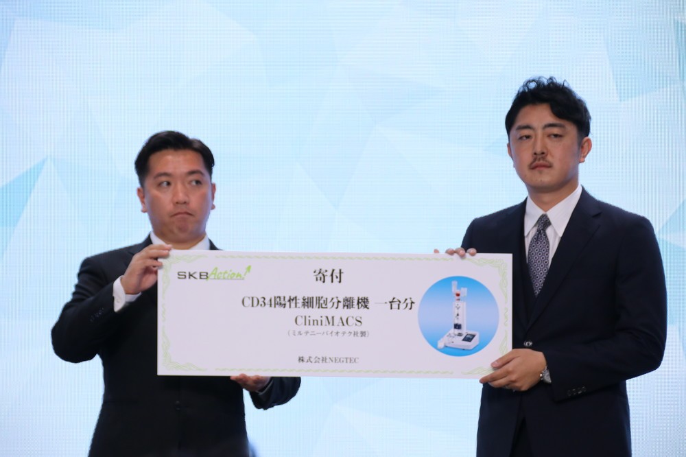 チャットドクター・草野正臣社長（写真右）に、「クリニーマックス」1台分の寄付を贈呈した（2018年8月撮影）