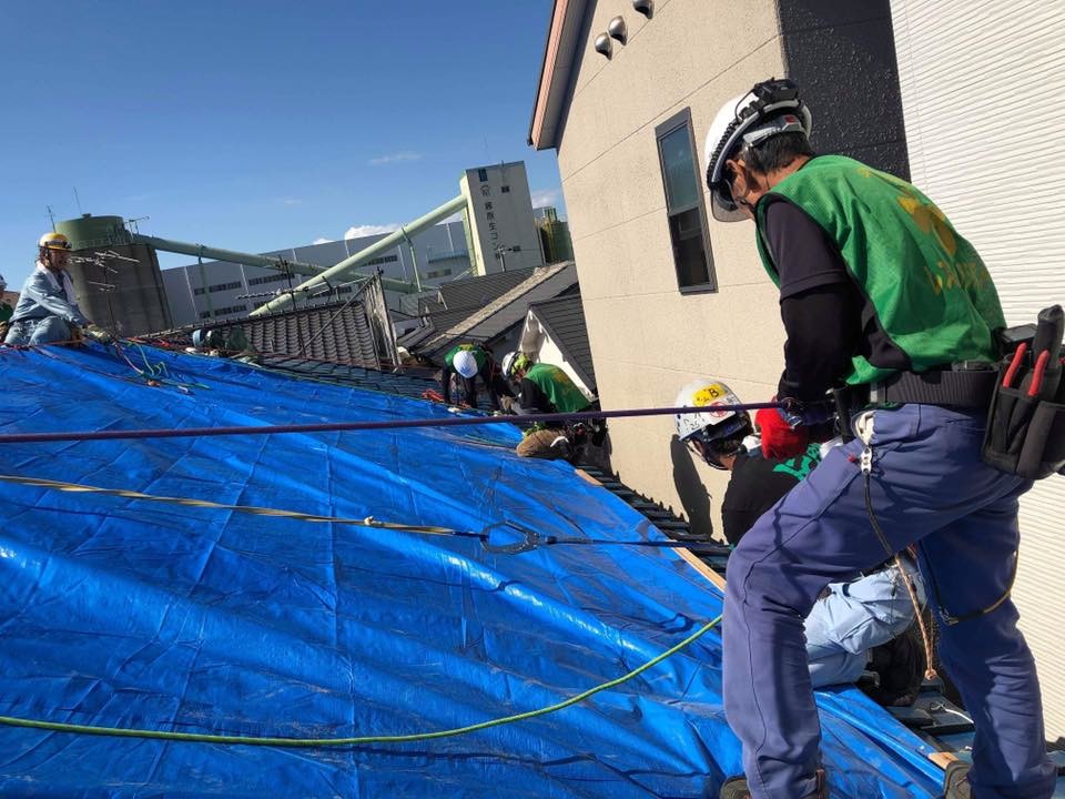 被害を受けた屋根にブルーシートを張る作業（写真提供：レスキューアシスト）