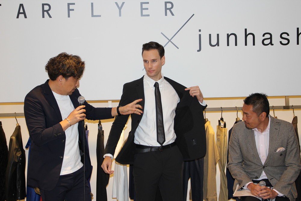 着用モデルを手で示しながらデザインの説明をする橋本氏