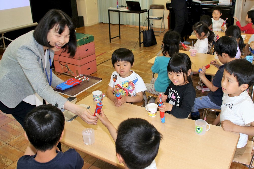 講師役のブラウン オーラルB・小川貴子さんが「すみずみクリーンキッズ」を園児たちに手渡し