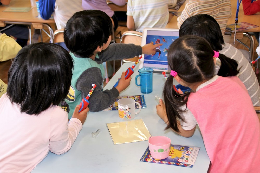 机に置かれたiPadに興味津々の園児たち