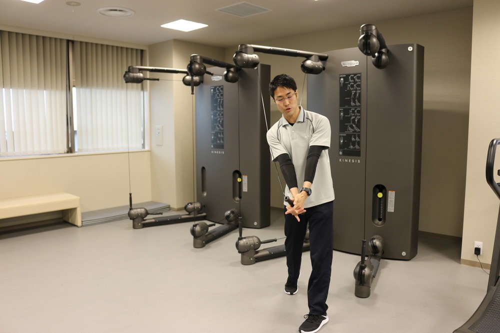 ゴルフのスウィングをして、機能的トレーニングを行う