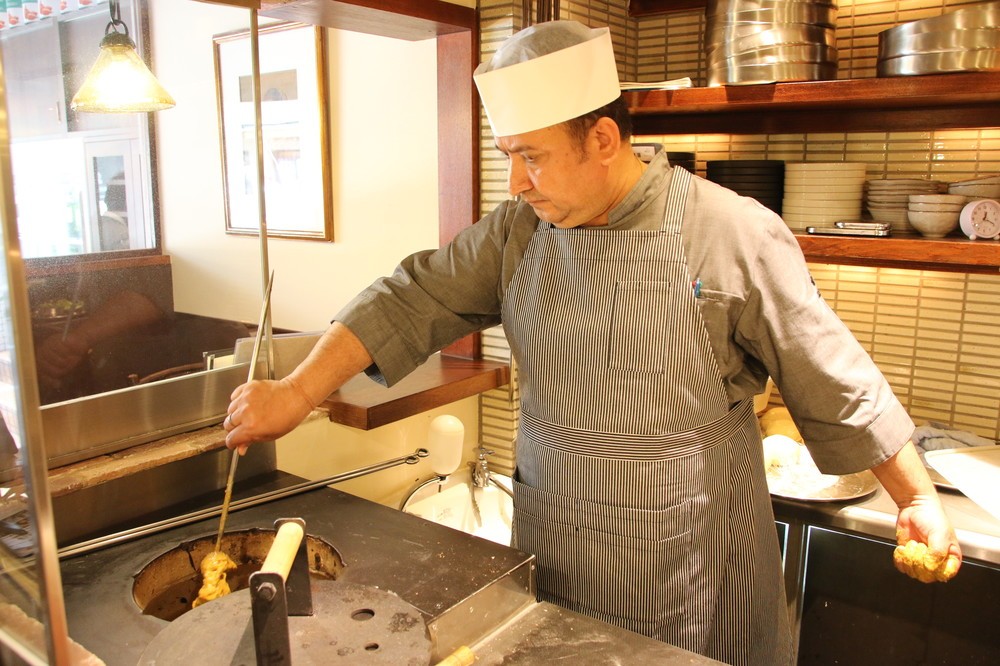 タンドール窯でチキンを焼くコックのマダンさん