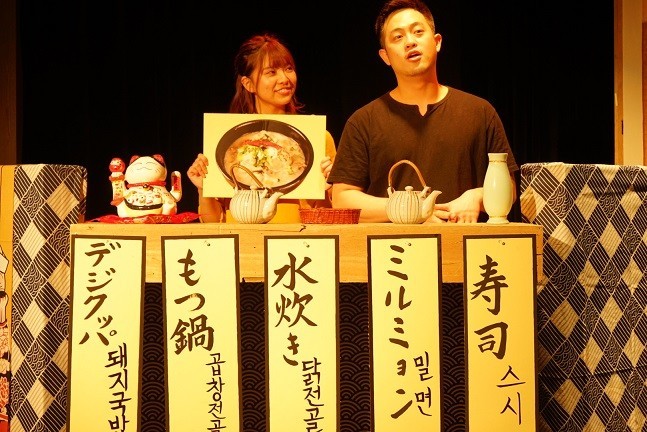 緊迫する幕間（まくあい）に福岡と釜山の食べ物を紹介するコーナーがある。似ている料理があると、観客席が和（なご）んだ（写真　HANARO project）