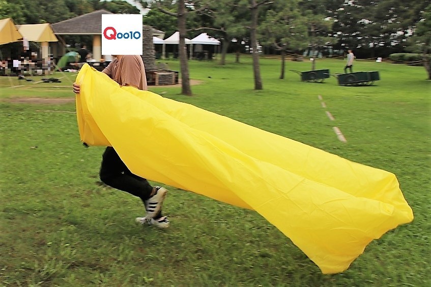 持参したエアーソファーを走って膨らませる、総合通販モール「Qoo10」担当者