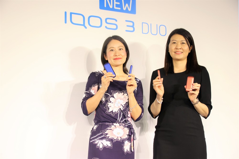 「IQOS 3 DUO」を持つシェリー・ゴー社長（右）と坂牧真美氏