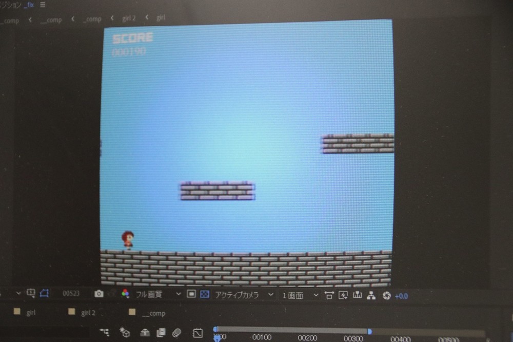 ファミコン風のドット絵をバックに歩くキャラクター