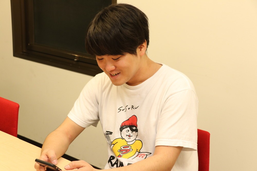 スマホでラーメン屋の情報を調べるSUSURUさん