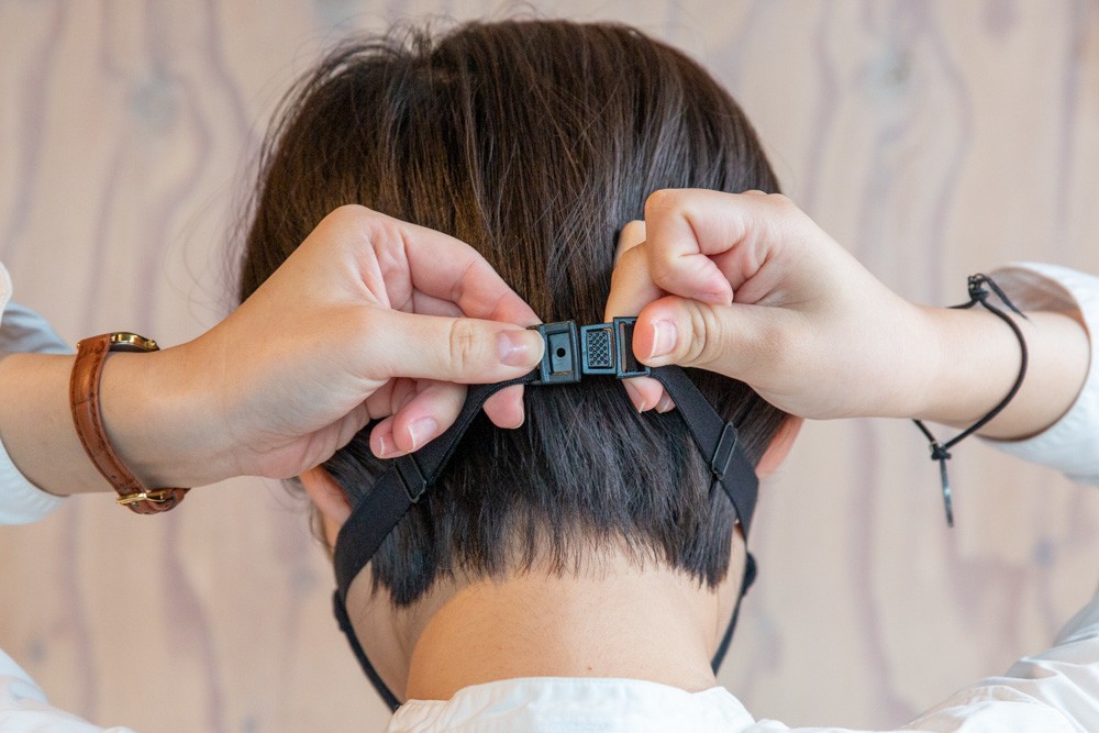 アジャスター付きゴムを調節して後頭部か首の後ろに回し、薄型のバックルで止める