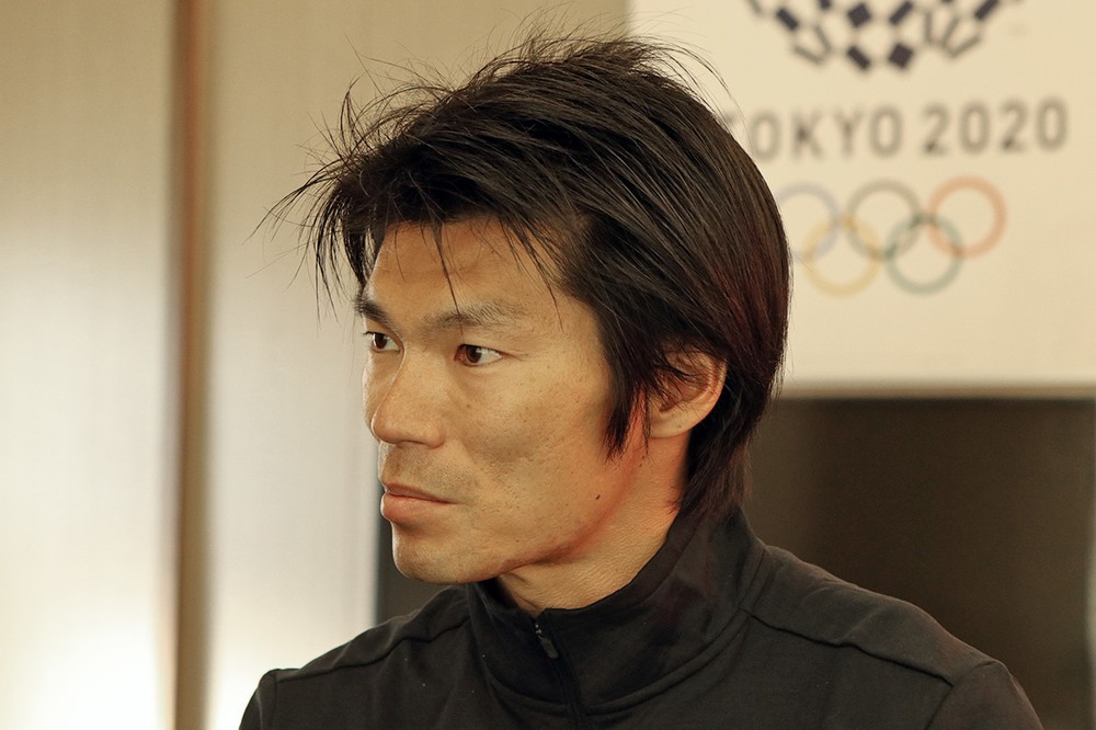 真剣な表情でインタビュアーの話を聞く