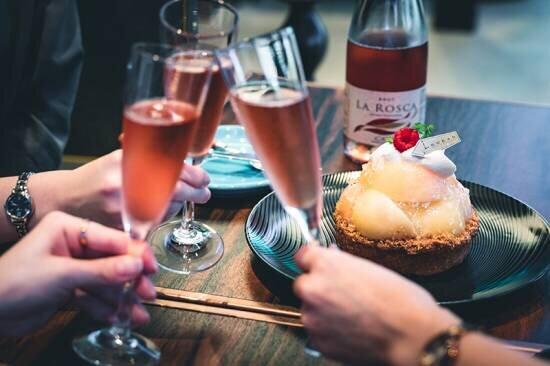 ケーキ、花、スパークリングワインでお祝い