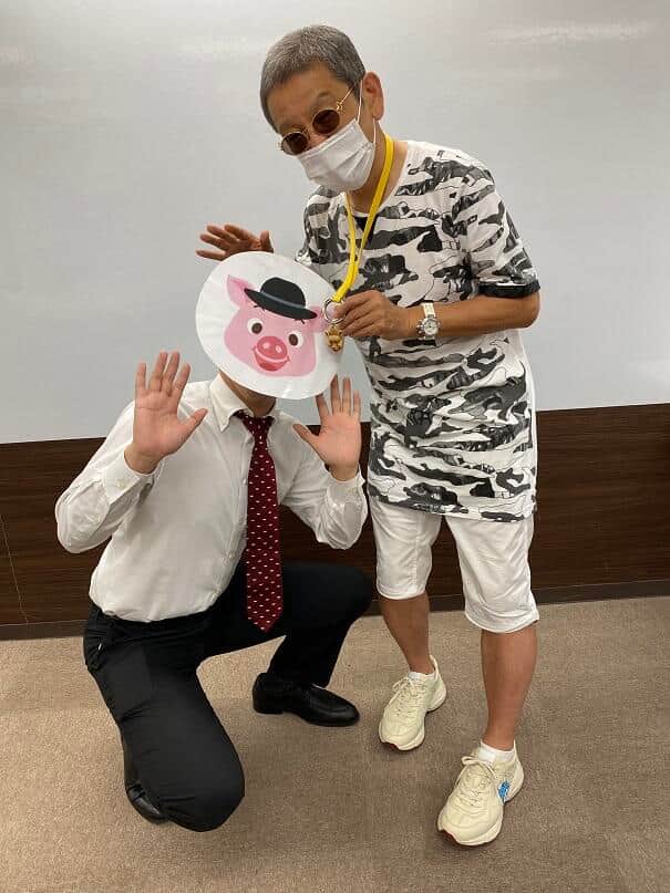 （左から）担当者と、無類のブタ好きであるホテルオーナー