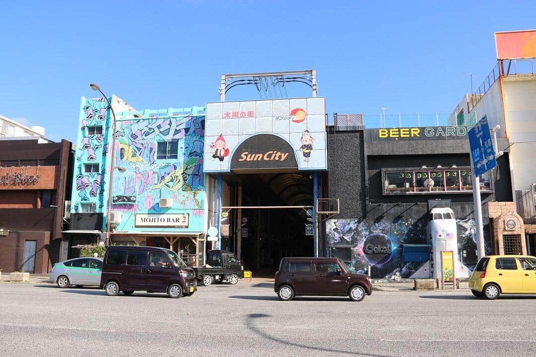 沖縄市の街はまるで映画のセットの中にいるような錯覚に陥る。米軍の基地の出口（ゲート）があるため、円建てとドル建ての2通りの表示がある店も