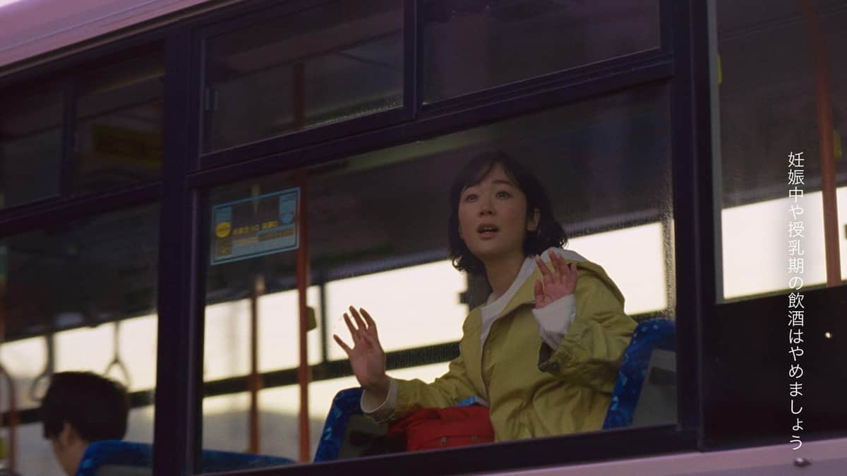 バスから、遠ざかるやきとり屋台を見つめる黒木さん（「帰りのバス」編）